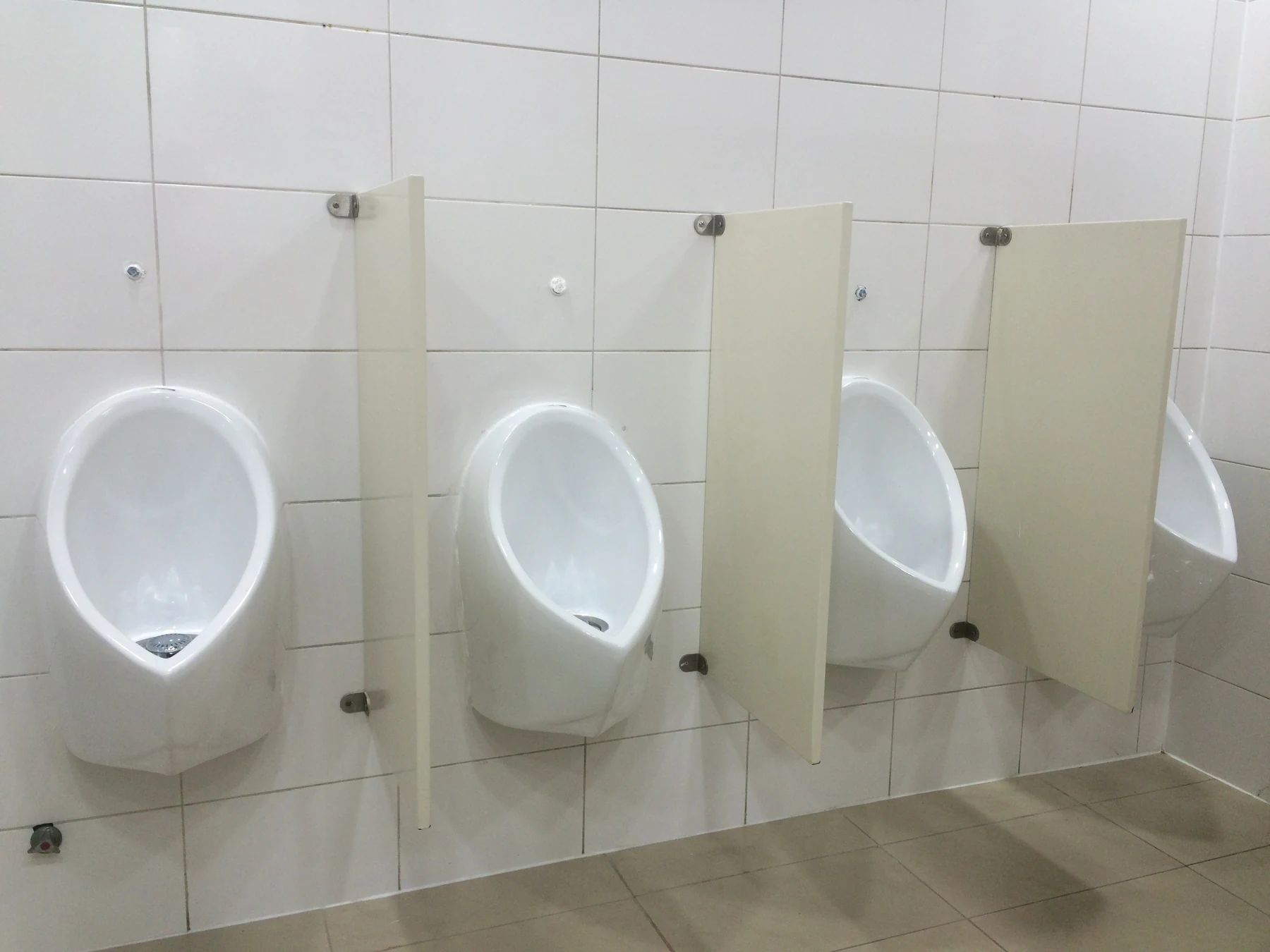 Urinarios ecológicos separados por paneles en un baño de uso compartido
