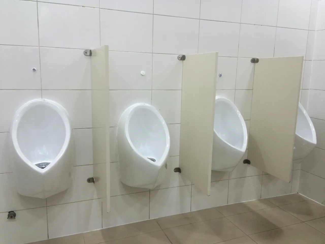 Urinarios ecológicos separados por paneles en un baño de uso compartido